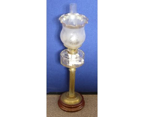 An Edwardian Brass Column Oil Lamp, the oil lamp having reeded stand on brown glazed pottery base, having an etched globe wit