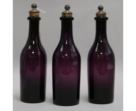 A set of three 19th century amethyst glass decanters, with plated stoppers, height 26cm