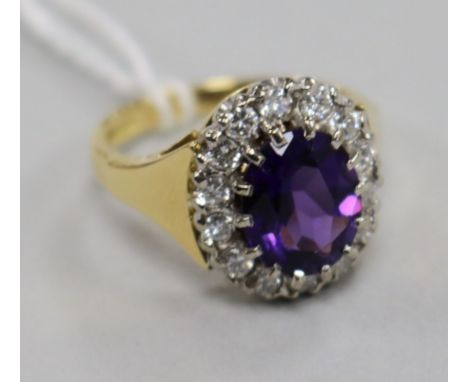 A modern 18ct gold, amethyst and diamond oval cluster ring, size L.