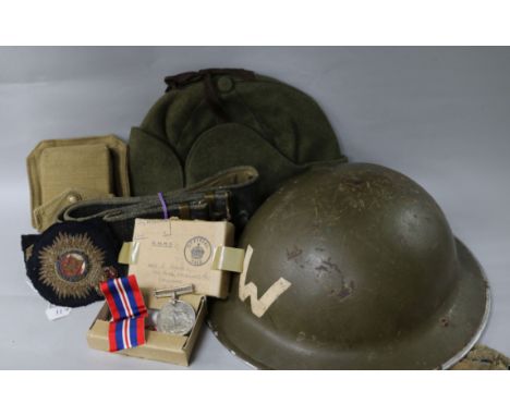 A British WW2 helmet, an army belt, a marching compass in case, a side cap, a US army hat, three naval cloth badges and a med