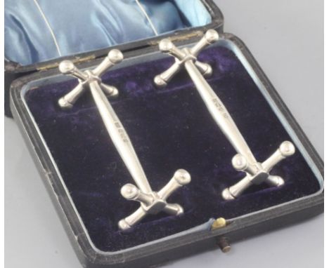 A cased pair of silver knife rests, George Howson, Sheffield, 1909/1910, 78mm.