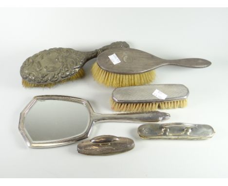 A matching machine turned silver backed dressing table mirror and brush, two further silver backed brushes and two silver bac