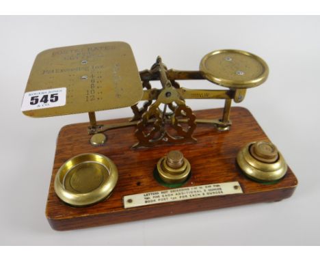 A lovely vintage set of postal scales on a wooden stand with weights and mounted instructions for letters, the letter dish wi