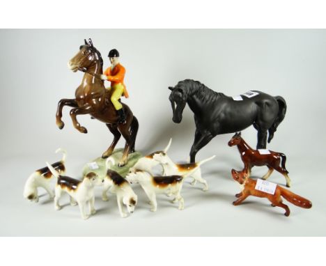 A Beswick model of a rearing mounted huntsman with seperate fox and six hounds together with a Beswick Black Beauty model and