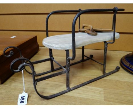 A charming wooden and iron model of a sleigh, 38cms long (possibly American) together with a carved novelty hand with carved 
