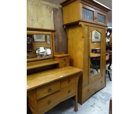 An Arts &amp; Crafts oak wardrobe, 204cms high x 105cms wide and matching dressing table, 99cms wide, the wardrobe with centr