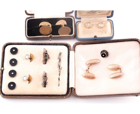 A pair of 9ct yellow gold cufflinks, the oval plaques with engine-turned decoration, together with a pair of 9ct rose gold cu