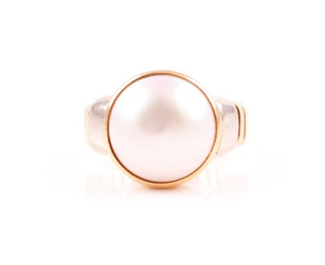 An 18ct yellow gold and mabe pearl ring, collet-set with a white pearl, approximately 14 mm diameter, within a yellow gold co