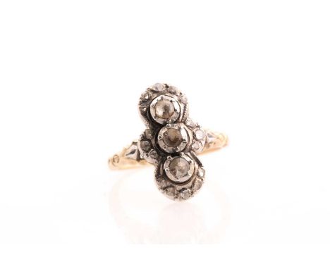 A yellow metal and diamond lozenge ring, set with three clusters of rose-cut diamonds, 2.1 cm long, the diamonds set in a sil