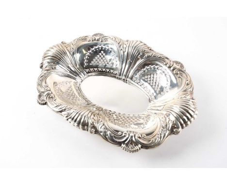 A silver oval shaped bowl, embossed with shells, leaves and scrolls, pierced with four arched panels, Birmingham 1902, possib