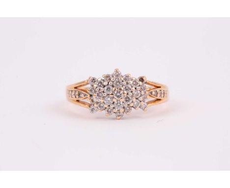 An 18ct yellow gold and diamond cluster ring, set with small round-cut diamonds (one lacking), with split detail to shoulders