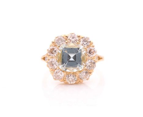 An 18ct yellow gold, diamond, and aquamarine cluster ring, set with a cushion-cut aquamarine of approximately 2.50 carats, su