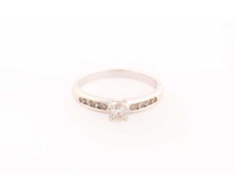 A single stone diamond ring; the principal round brilliant cut diamond in four claw mount above four stone diamond set should