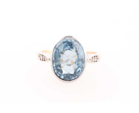 An 18ct white gold, diamond, and blue topaz ring, bezel-set with a mixed oval-cut topaz measuring approximately 12 x 10 mm, t