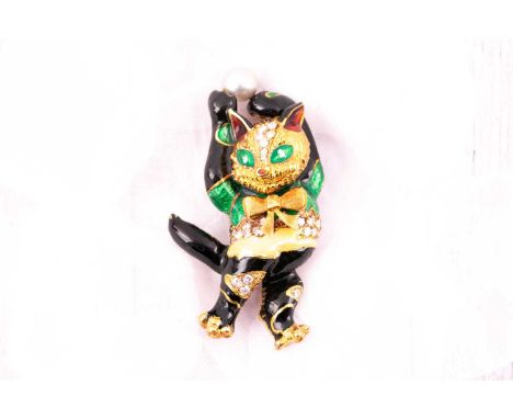 An 18ct yellow gold, diamond and enamel novelty brooch in the form of a smiling cat, holding a cultured pearl above his head,