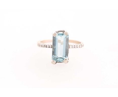 A diamond and aquamarine ring, set with an emerald-cut aquamarine measuring approximately 11.4 x 6.4 mm, four-claw set, each 