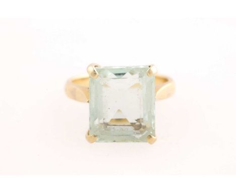 A single stone aquamarine dress ring, the rectangular cur-cornered, step cut aquamarine in four claw mount above scroll pierc