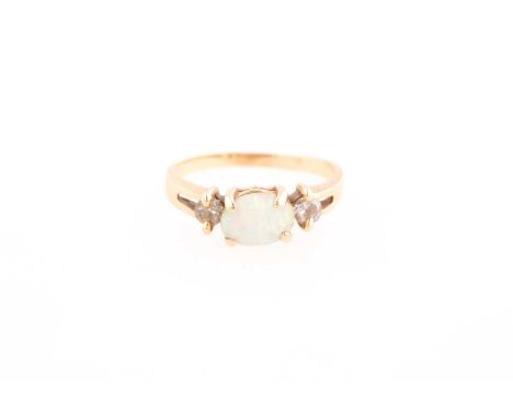 An opal and diamond three stone half hoop ring; the oval opal horizontally set between two round brilliant cut diamonds; claw