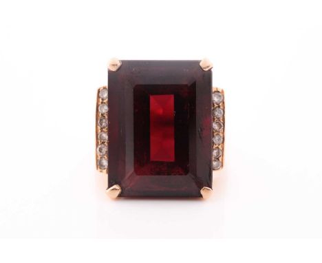 A yellow metal, diamond, and garnet ring, set with a mixed rectangular-cut garnet, measuring approximately 17 x 13.5 x 7.5 mm