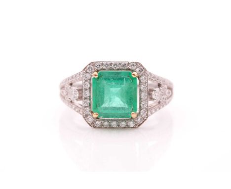 A diamond and emerald cocktail ring, set with a square-cut emerald of approximately 4.0 carats, within a border of round-cut 