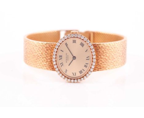 An 18ct yellow gold Patek philippe ladies watch, the oval gilt dial with Roman numerals, diamond-set bezel, on an articulated