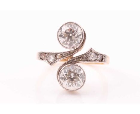 A Belle Epoque 'Toi et Moi' two stone diamond ring; the two old round brilliant cut diamonds in collet mounts, vertically pos