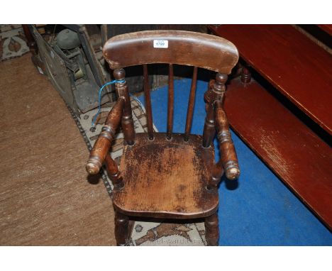 A 19th c. child's Rocking Chair, country made with stick back, turned arms on turned supports, Elm seat, turned legs on oak r