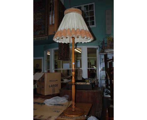 A turned wood Standard Lamp with cream and light brown shade