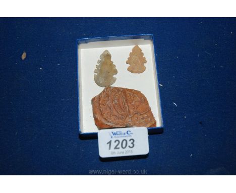 A fragment of ancient pottery and two arrow heads.