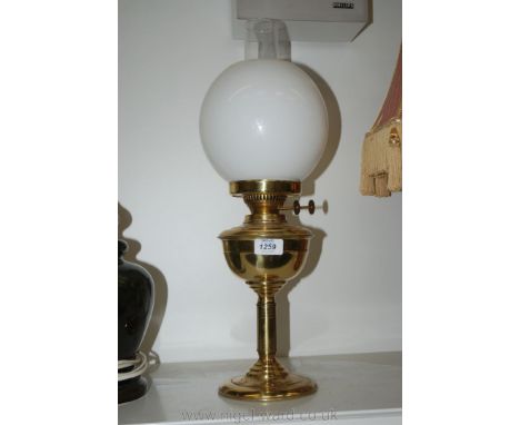 A Brass paraffin Lamp with a white shade