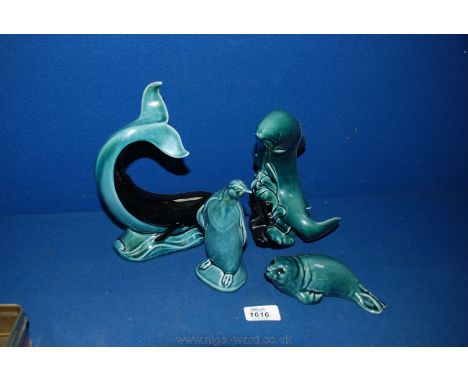 A Poole Pottery black whale, leaping salmon, seal pup and penguin.