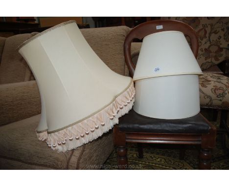 Two cream Lamp shades, one conical, the other tubular and a large cream shade with blush pink fringes and tassels