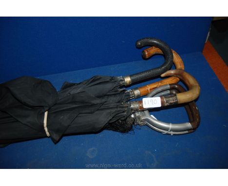 A black Umbrella with horn handle and silver band ''J. Smith, Conniston, Wigan Road, Bolton'' with two black Umbrellas and a 