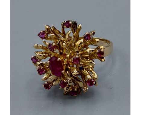 An 18ct gold ruby cluster ring, set with many rubies within a pierced setting, 7.3gms, ring size O 