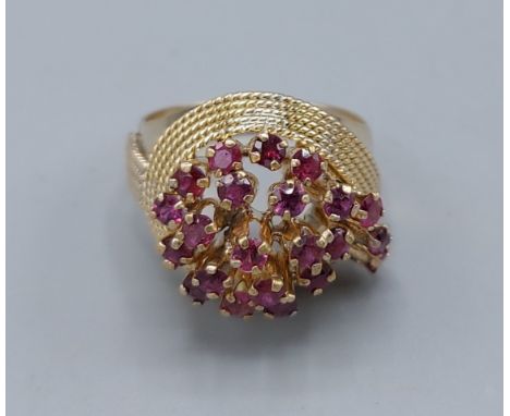 An 18ct gold ruby set cluster ring set with many rubies within a pierced setting, 7gms, ring size P 