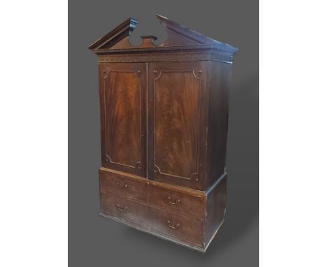 A 19th Century mahogany press cupboard, the moulded cornice above two panel doors enclosing sliding trays, the lower section 