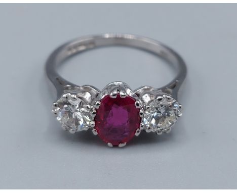 An 18ct white gold Ruby and Diamond three stone ring, the central oval Ruby approx. 1.05ct flanked by two brilliant cut Diamo