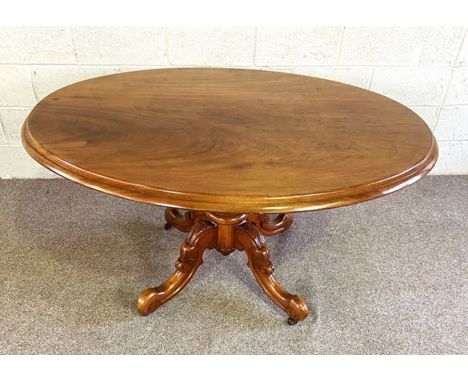 A Victorian mahogany oval hall or library table, circa 1870, with a moulded top, set on a ring turned pillar with four carved