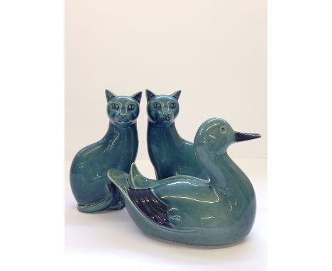 A pair of small opposite facing Poole Pottery blue glazed Cats together with a large blue glazed Duck.