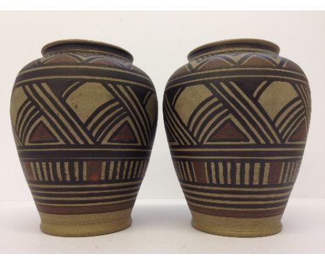 A near pair of early Poole Pottery unglazed hand painted vases with brown slips, after designs originating from James Radley 