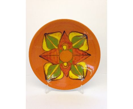 A large Poole Pottery Delphis dish, shape 54, decorated in an abstract floral pattern in tones of orange, green and yellow.