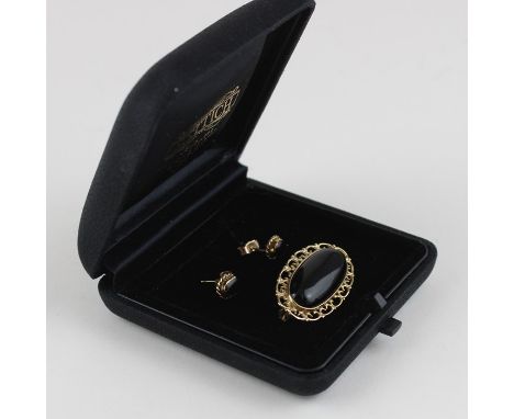 A 9ct yellow gold and onyx oval brooch and earrings en suite, the brooch set central oval cabochon onyx within pierced border