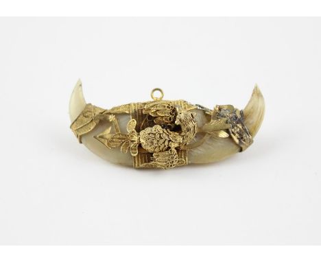 A late 19th century yellow metal and tigers claw pendant/brooch, having opposing upturned tigers claws set within fine filigr