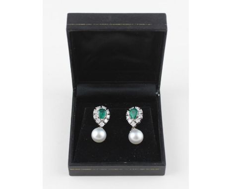 A pair of 18ct. white gold, emerald and diamond earrings with pearl drops, each set central pendeloque cut emerald surrounded