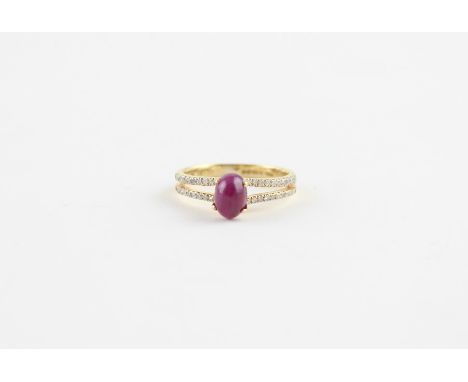 An 18ct. yellow gold, ruby and diamond dress ring,&nbsp;four claw set central oval cabochon ruby. the shoulders being of two 