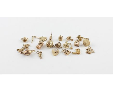 A collection of twenty 9ct. yellow and rose gold charms, to include; a canon, penny farthing bicycle, windmill, beam balance,