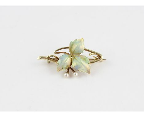 A 15ct. gold, enamel and seed pearl brooch,&nbsp;naturalistically fashioned as a twig with three gently curled leaves, each w