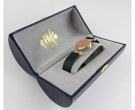 An 18ct. yellow gold Baume &amp; Mercier ladies' wrist watch, manual wind, having signed pink oval dial with gold dauphine ha