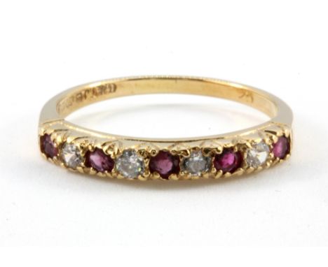 A 9ct yellow gold garnet and white stone set half eternity ring, (R).