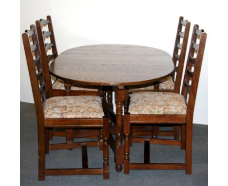 An oak drop leaf dining table and four ladder backed dining chairs.